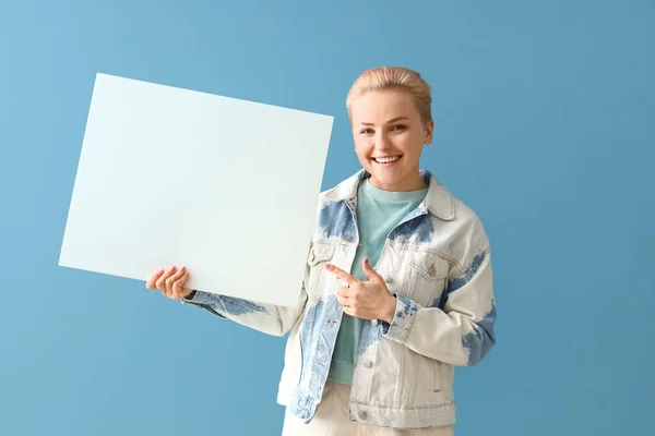 Young Woman Pointing Blank Poster Blue Background — Stock Photo, Image