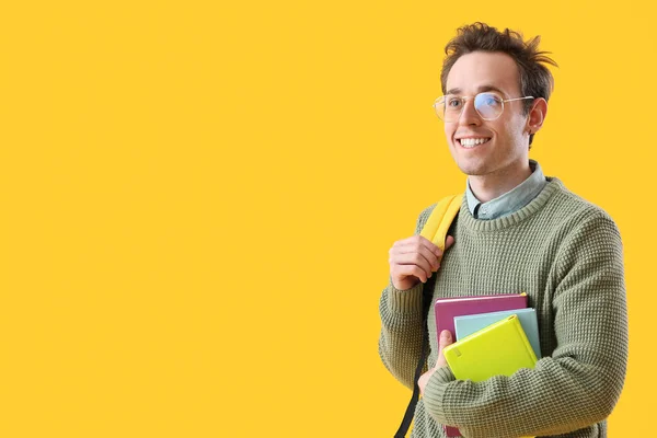 Männlicher Student Mit Notizbüchern Auf Gelbem Hintergrund — Stockfoto