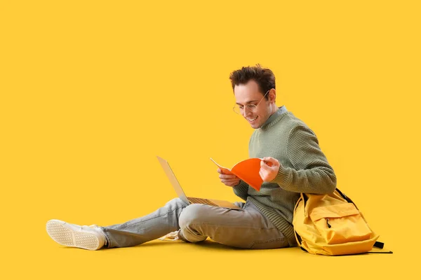 ノートパソコン ノートブック バックパック付き男性学生黄色の背景 — ストック写真