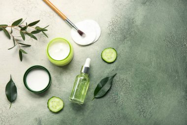 Doğal kozmetik ürünleri, pamuk pedleri ve grunge arkaplanındaki okaliptüs dalıyla kompozisyon