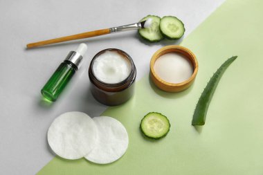 Doğal kozmetik ürünleri, malzemeler ve renk arkaplanına pamuk pedleri içeren kompozisyon