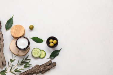Açık arkaplanda krema kavanozu ve doğal malzemelerle kompozisyon