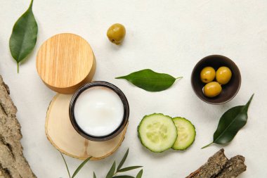 Açık arkaplanda krema kavanozu ve doğal malzemelerle kompozisyon