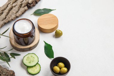 Açık arkaplanda krema kavanozu ve doğal malzemelerle kompozisyon