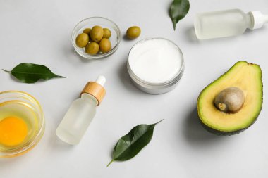 Doğal kozmetik ürünleri, malzemeler ve bitki yapraklarıyla hafif arkaplanda bileşim