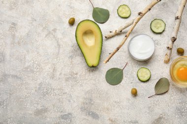 Doğal krema kavanozu, malzemeler ve arkaplanda bitki dalları olan kompozisyon