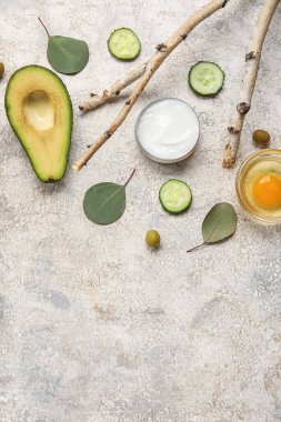 Doğal krema kavanozu, malzemeler ve arkaplanda bitki dalları olan kompozisyon