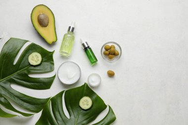 Hafif arkaplanda doğal kozmetik ürünleri, malzemeler ve palmiye yaprakları ile kompozisyon