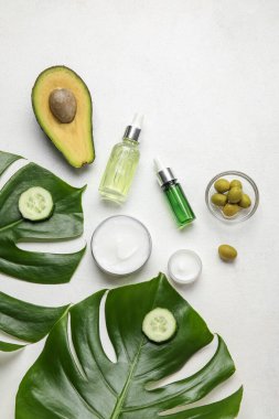 Hafif arkaplanda doğal kozmetik ürünleri, malzemeler ve palmiye yaprakları ile kompozisyon