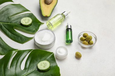 Hafif arkaplanda doğal kozmetik ürünleri, malzemeler ve palmiye yaprakları ile kompozisyon