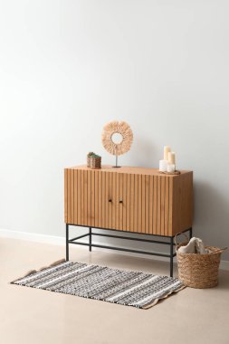 Beyaz duvarın yanındaki ahşap dolap.