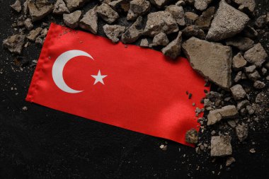 Koyu arkaplanda taş döküntüleri olan Türk bayrağı. Türkiye deprem kavramı