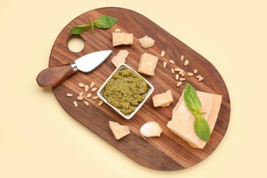 Bir kase lezzetli pesto sosu ve sarı arka planda malzemeler.