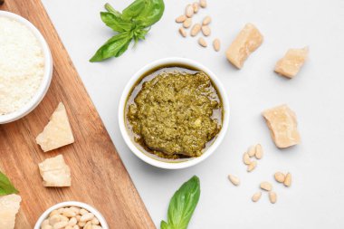 İçinde pesto sosu ve gri arka planda malzemeler olan kompozisyon.