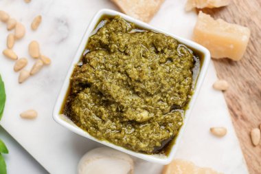 Lezzetli pesto sosu ve malzemelerle dolu bir pano. Yakın plan.