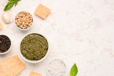 İçinde pesto sosu ve beyaz masa malzemesi olan kompozisyon.