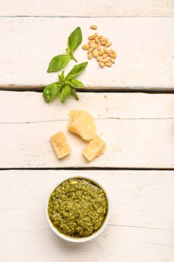 İçinde pesto sosu ve beyaz ahşap masa malzemesi olan kompozisyon.
