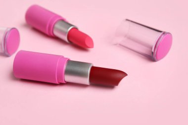 Pembe arka planda farklı ruj izleri, yakın plan.