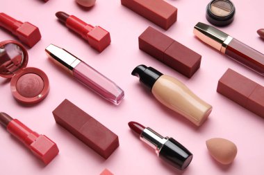 Pembe arka planda ruj lekeleri olan dekoratif kozmetik ürünler, yakın plan.