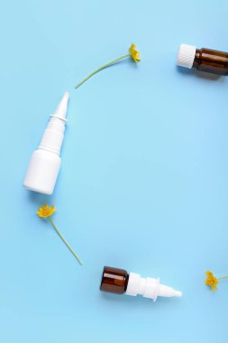 Mavi arka planda çiçekli damlalardan yapılmış bir çerçeve. Mevsimsel alerji kavramı