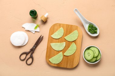 Salatalık dilimleri ve bej arkaplandaki malzemelerle göz altı pamuklu bantlar