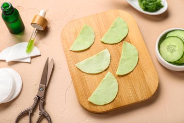 Salatalık dilimleri ve bej arkaplandaki malzemelerle göz altı pamuklu bantlar