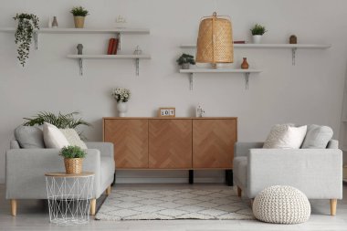 Rahat kanepeleri ve ahşap dolabı olan şık bir oturma odası.