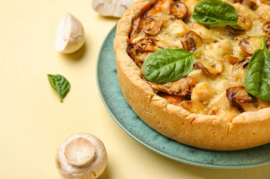 Sarı arka planda ıspanak yapraklı mantar turtası ve şampiyonlar.