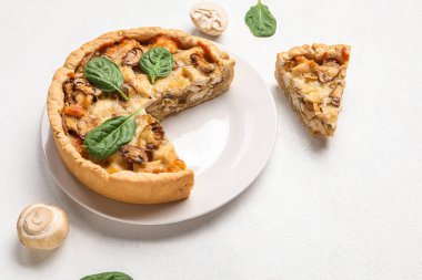 Beyaz grunge masasında ıspanak yapraklı mantar turtası ve şampiyonlar.