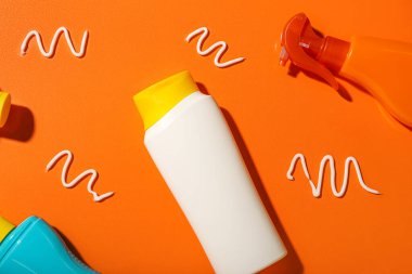 Turuncu arka planda farklı güneş kremleri