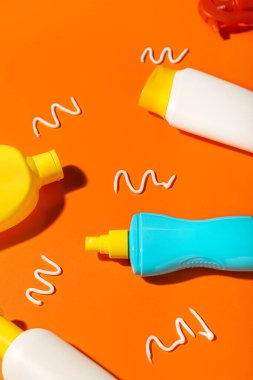 Turuncu arka planda farklı güneş kremleri