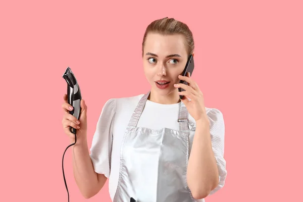 Kobieta Fryzjer Przycinaczem Rozmowy Przez Telefon Komórkowy Różowym Tle — Zdjęcie stockowe
