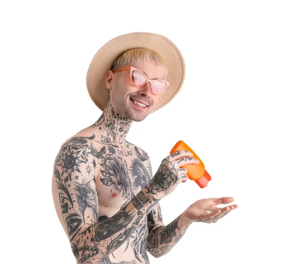 Tattooed man with sunscreen cream on white background