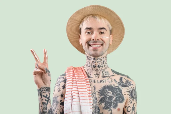 Tatuerad Man Som Tillämpar Solkräm Ljusgrön Bakgrund — Stockfoto