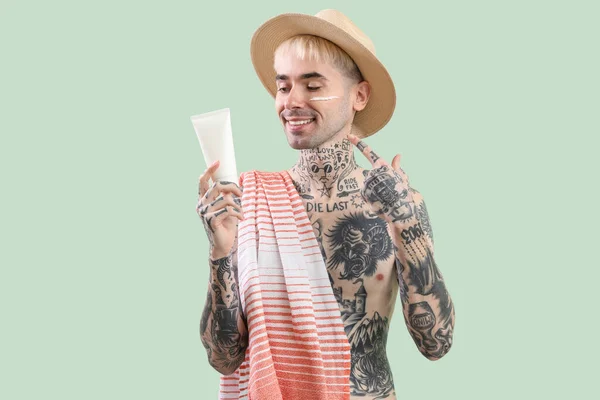Uomo Tatuato Con Crema Solare Sfondo Verde Chiaro — Foto Stock
