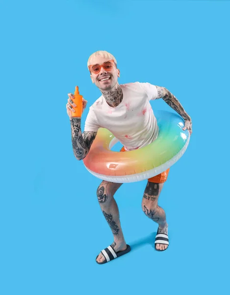 Τατουάζ Άνθρωπος Αντηλιακή Κρέμα Και Δαχτυλίδι Κολύμπι Γαλάζιο Φόντο — Φωτογραφία Αρχείου