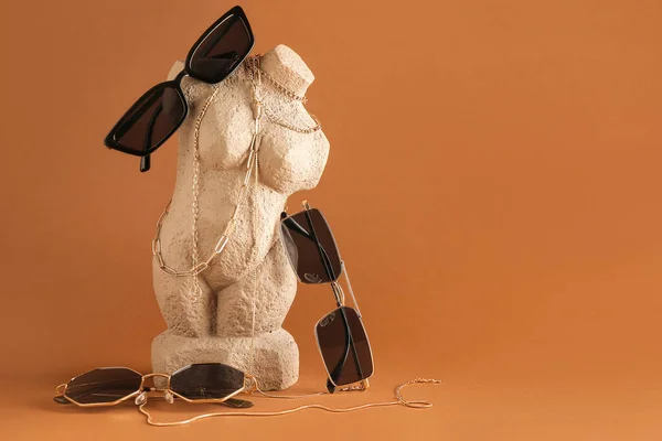 Statuette Stylish Sunglasses Jewelry Brown Background — Stock Photo, Image