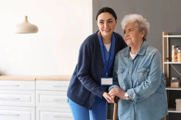 Giovane Badante Aiutare Donna Anziana Con Bastone Passeggio Cucina — Foto Stock