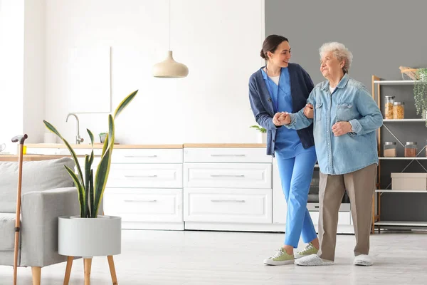 Young Caregiver Helping Senior Woman Walk Kitchen — Stock Photo, Image