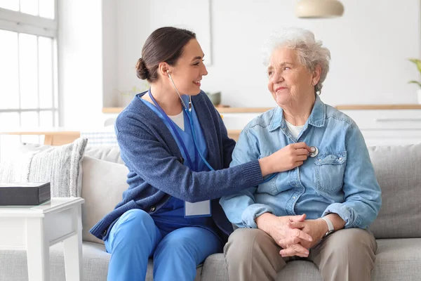 Young Caregiver Hearing Senior Woman Stethoscope Home — Stock Photo, Image