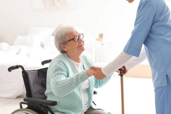 老人ホームで介護者と車椅子の女性 — ストック写真