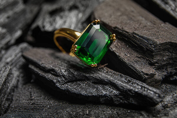 Golden ring on black charcoal, closeup