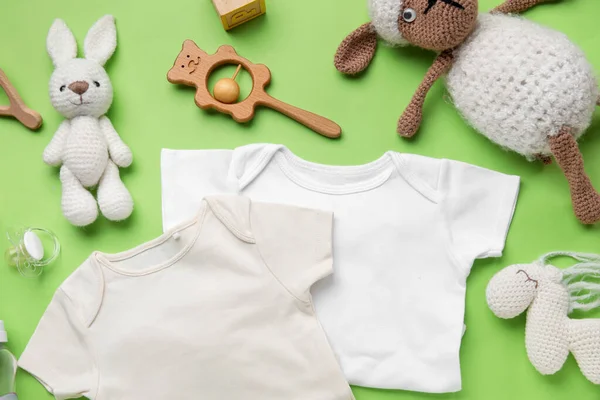Açık Yeşil Arka Planda Bebek Kıyafetleri Oyuncakları Olan Kompozisyon — Stok fotoğraf