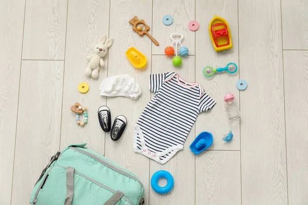 Stylish Bag Clothes Toys Baby Light Wooden Background — Stock Photo, Image