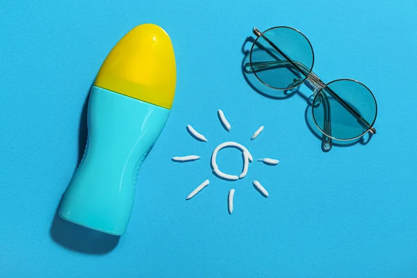 Disegni Sole Realizzati Con Crema Solare Occhiali Sole Sfondo Blu — Foto Stock
