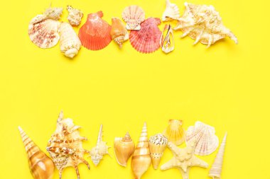 Sarı arka planda deniz yıldızı ve deniz kabuklarından yapılmış çerçeve