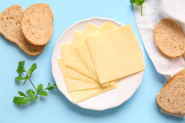 Lezzetli işlenmiş peynir tabağı ve mavi arka planda ekmek.