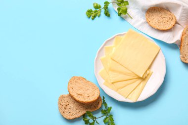 Lezzetli işlenmiş peynir tabağı ve mavi arka planda ekmek.