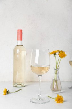 Beyaz masada bir şişe karahindiba şarabı.