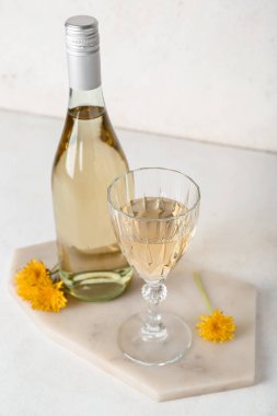 Beyaz masada şişe ve bir bardak karahindiba şarabı.